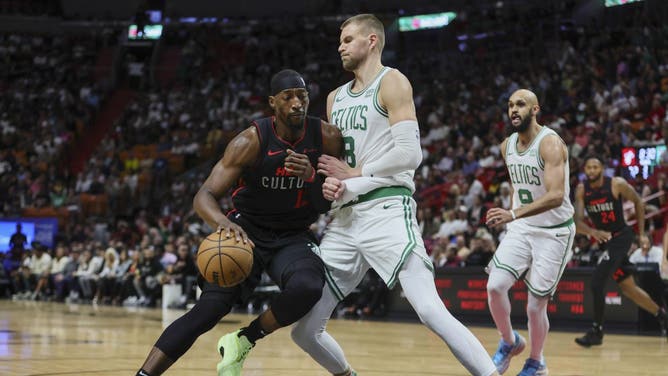 Miami Heat big Bam Adebayo drives to the basket on Boston Celtics big Kristaps Porzingis during the third quarter at Kaseya Center in Florida.