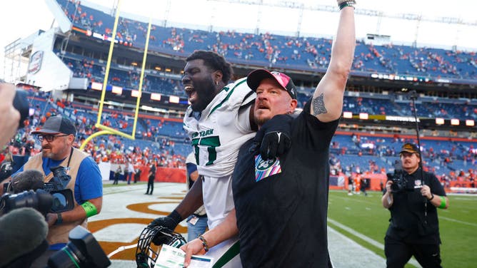 Mekhi Becton and offensive coordinator Nathaniel Hackett of the New York Jets celebrate after beating Sean Payton and the Denver Broncos 31-21 at Empower Field At Mile High on October 08, 2023 in Denver, Colorado.
