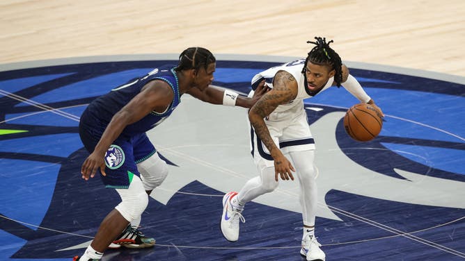 Grizzlies PG Ja Morant dribbles the ball while Timberwolves SF Anthony Edwards defends him in the 4th quarter during Game 6 of the Western Conference First Round at Target Center in Minneapolis.