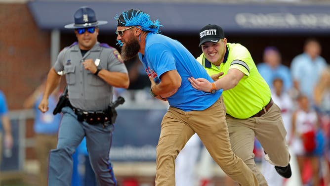 A fan is tackled by security as he rushes the field during the Ole Miss game against Auburn.