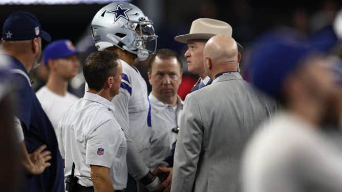 Cowboys QB Dak Prescott has his hand examined by team surgeon Dr. Dan Cooper