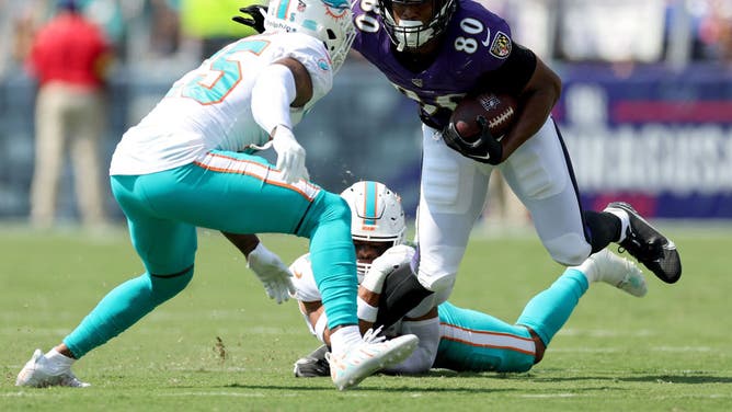 Isaiah Likely is tackled by Xavien Howard and Brandon Jones during the game Baltimore Ravens' home game against the Miami Dolphins in Week 2 of the NFL season