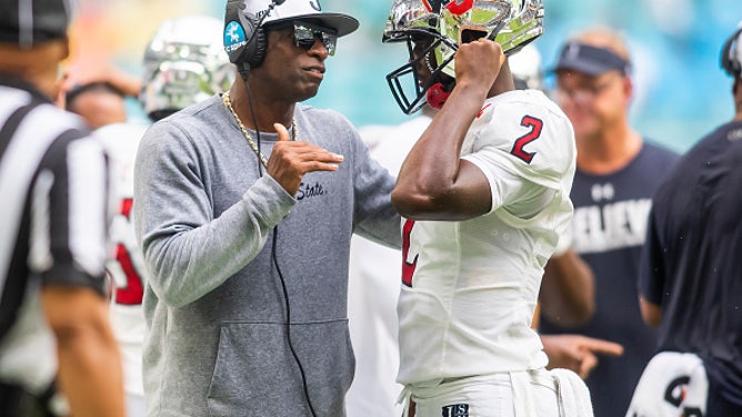 Jackson State Tigers head coach Deion Sanders speaks with his son, quarterback Shedeur Sanders, during a game. Shadeur will now rep Tom Brady's apparel brand.