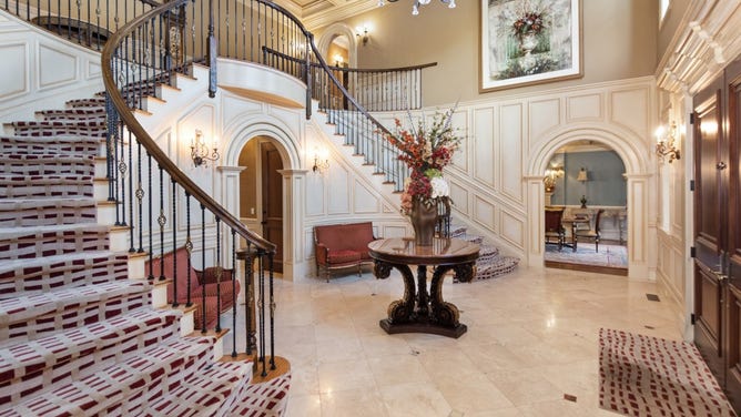 The grand foyer with a cinderella-style staircase.