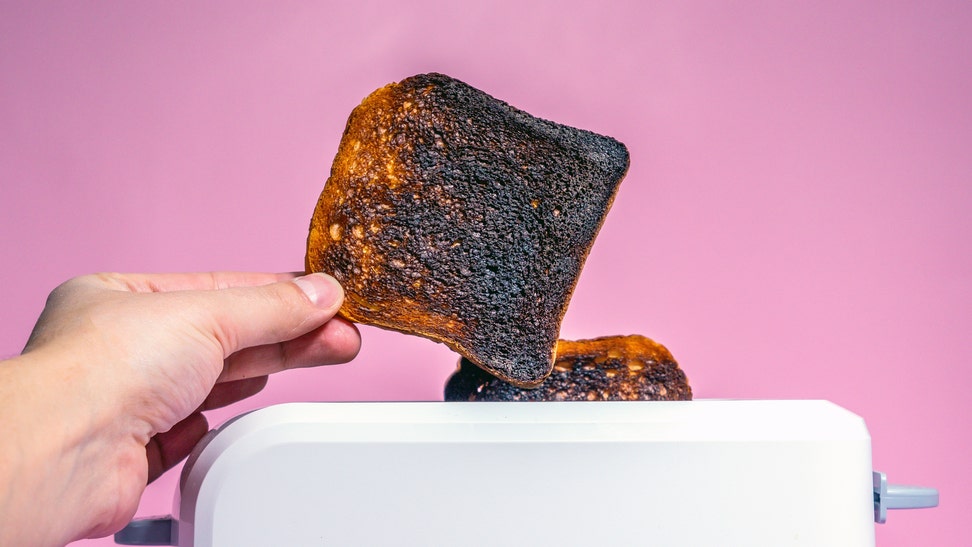 1c6a58e6-burnt bread toast in the toaster