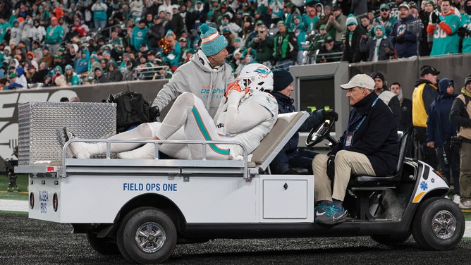Miami Dolphins linebacker Jaelan Phillips (15) is driven off the field after an apparent injury during the second half against the New York Jets at MetLife Stadium.