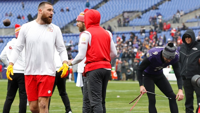 Kansas City Chiefs tight end Travis Kelce (87) exchanges words with Baltimore Ravens place kicker Justin Tucker (9) for warming up in the Chiefs' facility prior to the AFC Championship football game at M&T Bank Stadium