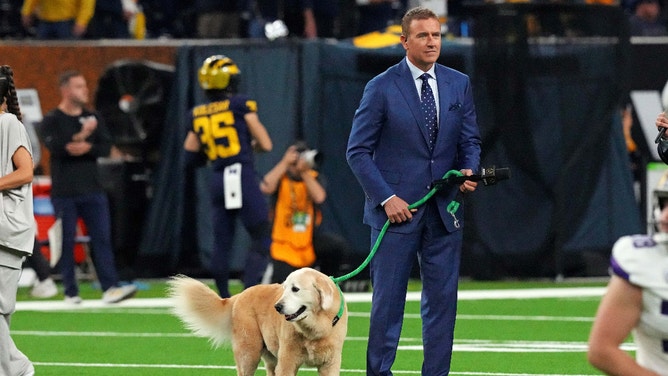 ESPN analyst Kirk Herbstreit walks his dog, Ben, before the 2024 College Football Playoff National Championship game at NRG Stadium. 