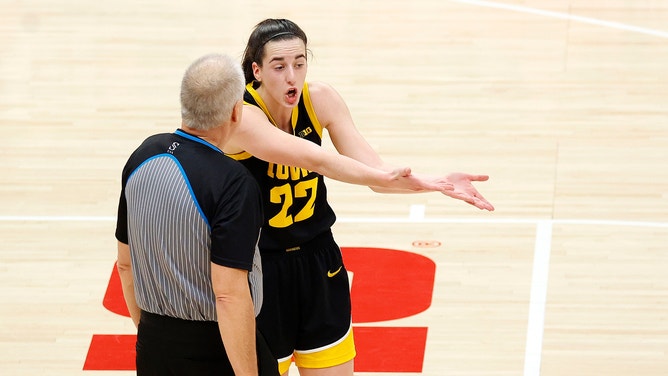 Iowa Star Caitlin Clark complains to a referee about a foul call during a college basketball game.