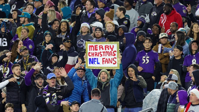 NFL fans watch with a Merry Christmas sign during a game between the Baltimore Ravens and Jacksonville Jaguars.