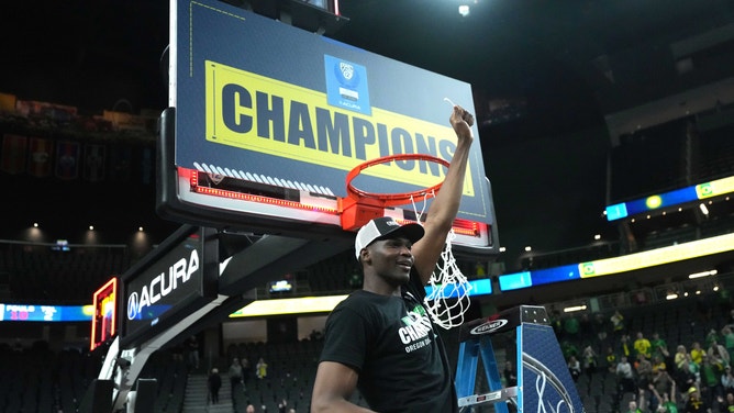 Oregon Ducks center N'Faly Dante cuts down the net after the Pac-12 Championship game against the Colorado Buffaloes.