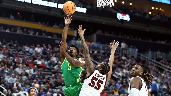 Jermaine Couisnard of the Oregon Ducks goes to the basket against Ta'Lon Cooper of the South Carolina Gamecocks during the first round of the NCAA Men's Basketball Tournament.