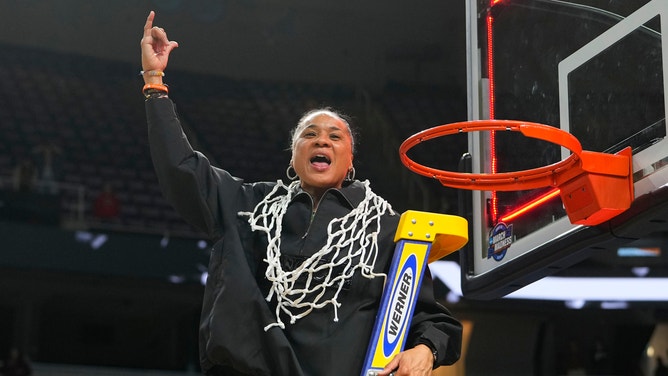 South Carolina Gamecocks head coach Dawn Staley celebrates cutting down the net after advancing to the Final Four in the 2024 NCAA Tournament. 