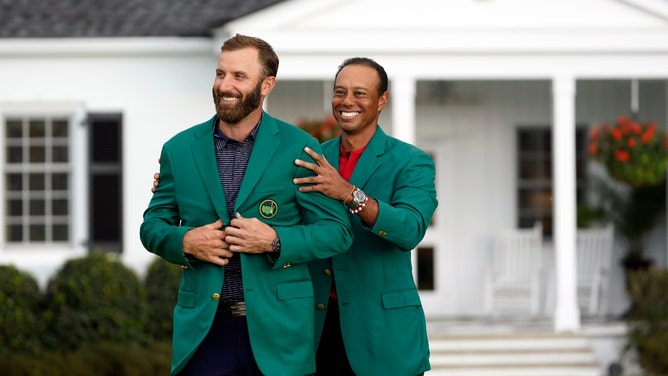 Reigning Masters champion Tiger Woods presents Dustin Johnson with the green jacket after winning The 2020 Masters golf at Augusta. (Michael Madrid-USA TODAY Sports)