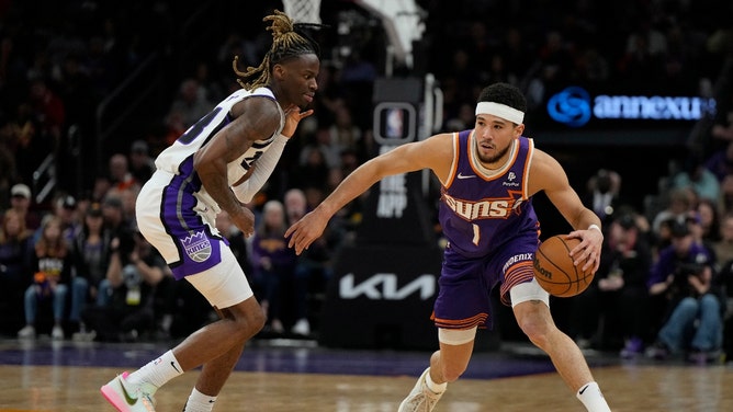 Phoenix Suns SG Devin Booker drives to the point on Sacramento Kings SG Keon Ellis at Footprint Center in Arizona. (Rick Scuteri-USA TODAY Sports)