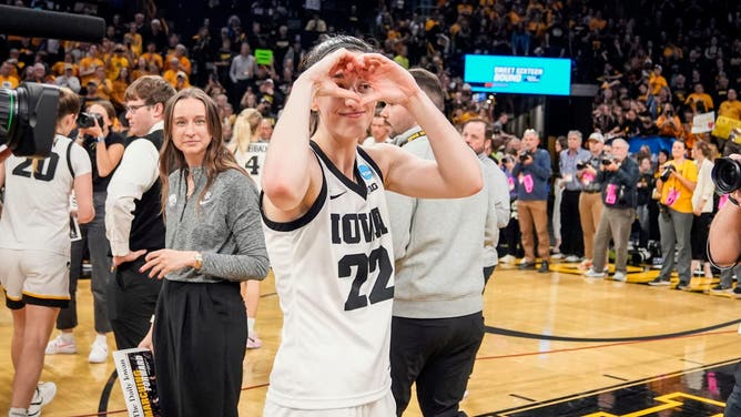 Iowa Hawkeyes guard Caitlin Clark (22) makes a heart as Iowa players celebrate after a second-round NCAA Tournament game between Iowa and West Virginia, Monday, March 25, 2024 at Carver Hawkeye Arena in Iowa City.