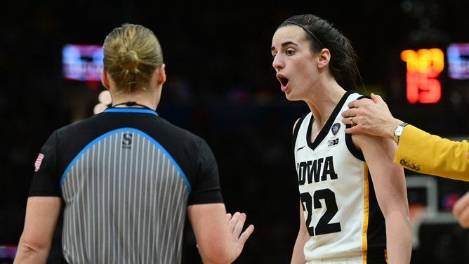 Iowa Hawkeyes guard Caitlin Clark argues with a referee while a coach attempts to pull her away during the team's Final Four win over the Connecticut Huskies.