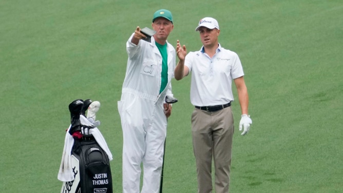 Justin Thomas and his caddie, Jim "Bones" Mackay, line up their shot on the no. 7 fairway during a practice round for The Masters golf tournament in 2023 at Augusta National Golf Club.