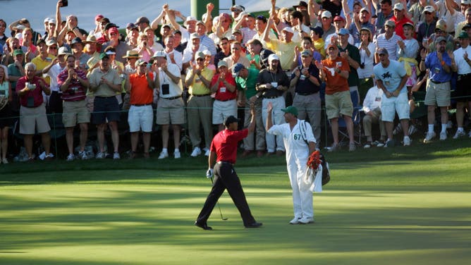 Tiger Woods and caddie Steve Williams celebrate after Woods holed-out his chip on the 16th hole during the final round of the 2005 Masters, which was iconically called by Verne Lundquist.