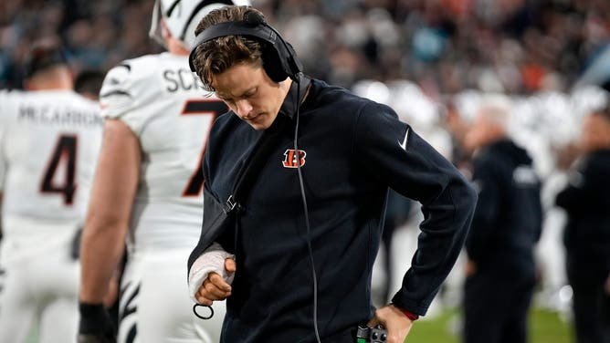 Cincinnati Bengals QB Joe Burrow adjusts his headset while on the sideline after suffering a season-ending wrist injury.