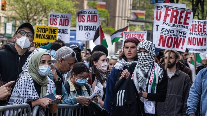 Several hundred anti-Israel protestors stand outside the gates of Columbia University with signs promoting Palestine and Hamas.