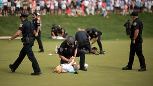 Idiot climate change protestors are ushered off the 18th green by police officers during the final round of the Travelers Championship at TPC River Highlands on June 23, 2024 in Cromwell, Connecticut. (Photo by James Gilbert/Getty Images)