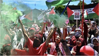 A group of anti-America/anti-Israel protesters threw bottles at a park ranger during a massive rally near the White House. Watch the footage. (Credit: Getty Images)