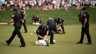 Idiot climate change protestors are ushered off the 18th green by police officers during the final round of the Travelers Championship at TPC River Highlands on June 23, 2024 in Cromwell, Connecticut. (Photo by James Gilbert/Getty Images)