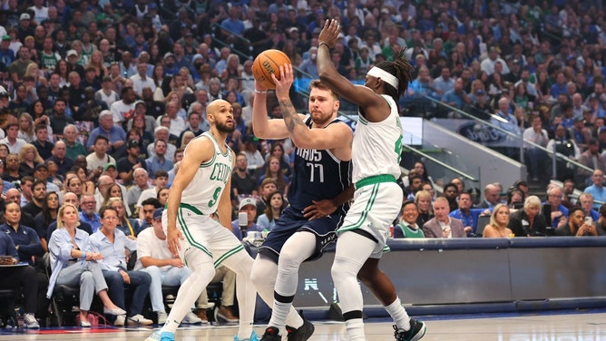 Dallas Mavericks All-Star Luka Doncic drives to the paint on Boston Celtics guards Derrick White and Jrue Holiday in Game 5 of the 2024 NBA Finals at American Airlines Center. (Stacy Revere/Getty Images)
