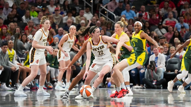 Indiana Fever SG Caitlin Clark looks for an open teammate while being double-teamed by the Seattle Storm at Gainbridge Fieldhouse. (Joe Timmerman/IndyStar/USA TODAY NETWORK) 