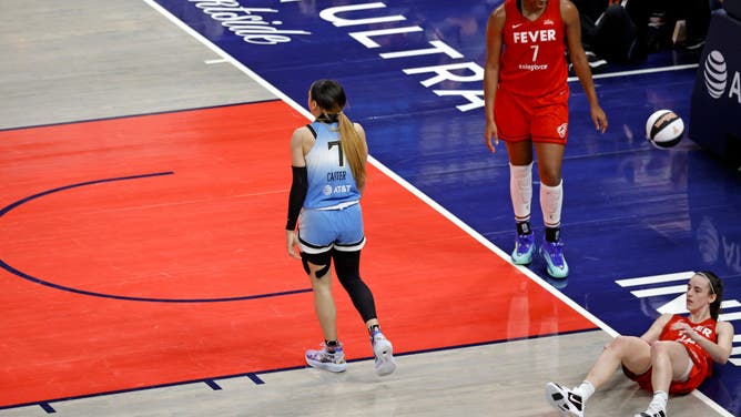 Chicago Sky guard Chennedy Carter is whistled for a foul after knocking Indiana Fever guard Caitlin Clark to the ground during a WNBA game.