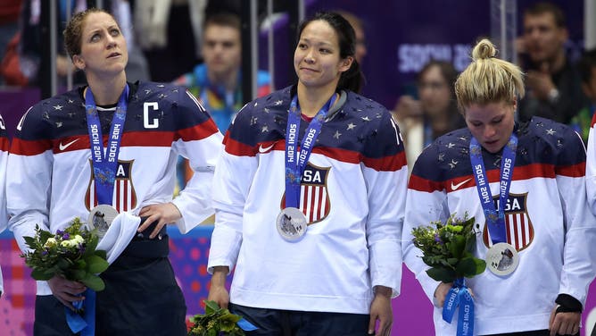 Meghan Duggan, Julie Chu and Brianna Decker of Team USA, coached by Katey Stone, react during the flower ceremony after losing to Canada 3-2 during the Ice Hockey Women's Gold Medal Game at the 2014 Winter Olympics.