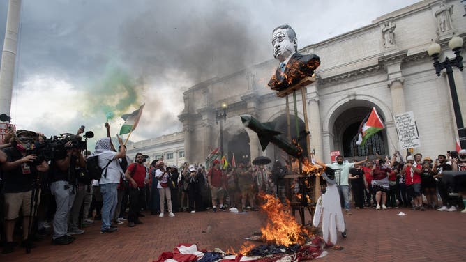 Protesters burn an American Flag outside of Union Station following Israeli Prime Minister Benjamin Netanyahu's address during a joint session of congress, in Washington, DC on July 24, 2024. (Photo by Matthew Hatcher / AFP) (Photo by MATTHEW HATCHER/AFP via Getty Images)