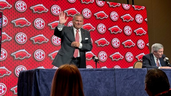 Sam Pittman waves to the media as he takes the stage to talk about his Arkansas Razorbacks football program at SEC Media Days