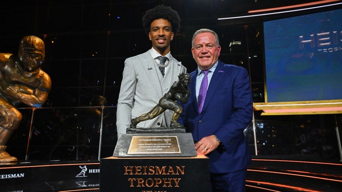 Former LSU Tigers QB Jayden Daniels and head coach Brian Kelly post with the Heisman Trophy. (Todd Van Emst/Heisman Trust/Pool-USA TODAY Sports)