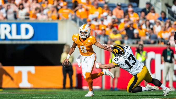 Tennessee Volunteers QB Nico Iamaleava stiff arms a Iowa Hawkeyes defender in the Citrus Bowl at Camping World Stadium in Orlando, Florida. (Jeremy Reper-USA TODAY Sports)