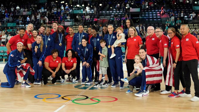 Team USA celebrates with family on the court after defeating France in the women's basketball gold medal game during the Paris 2024 Olympic Summer Games at Accor Arena.