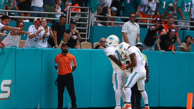 Miami Dolphins WR Jaylen Waddle pretends to put Tyreek Hill in handcuffs after Hill scored a touchdown against the Jacksonville Jaguars in Sunday's game.