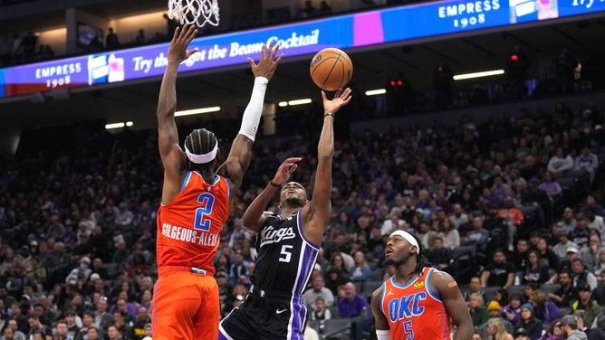 Sacramento Kings PG De'Aaron Fox takes a layup over Oklahoma City Thunder PG Shai Gilgeous-Alexander at Golden 1 Center. (Darren Yamashita-Imagn Images)