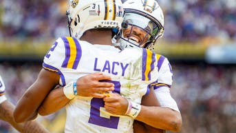 Kyren Lacy and Jayden Daniels celebrate a touchdown against Texas A&amp;M in 2023.