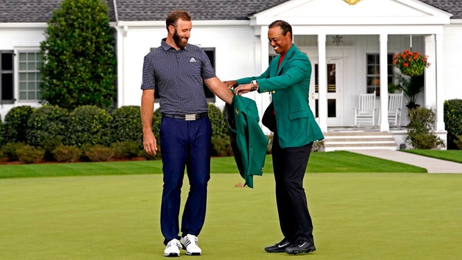 2019 Masters champion Tiger Woods presents Dustin Johnson with the green jacket after winning The 2020 Masters at Augusta National. (Photo credit: Rob Schumacher-Imagn Images)
