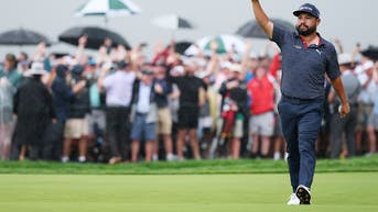 JJ Spaun holding his hand up