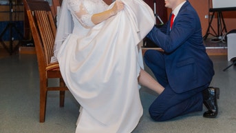Groom uses teeth in viral video to remove garter from bride's leg