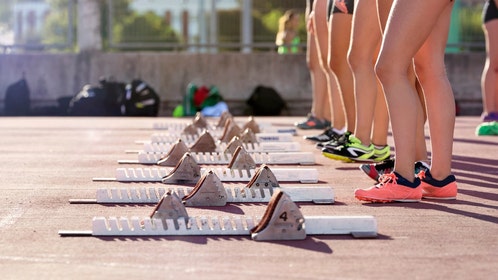 Girls track athletes line up at the start line