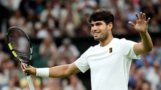 Carlos Alcaraz smiles at Wimbledon.