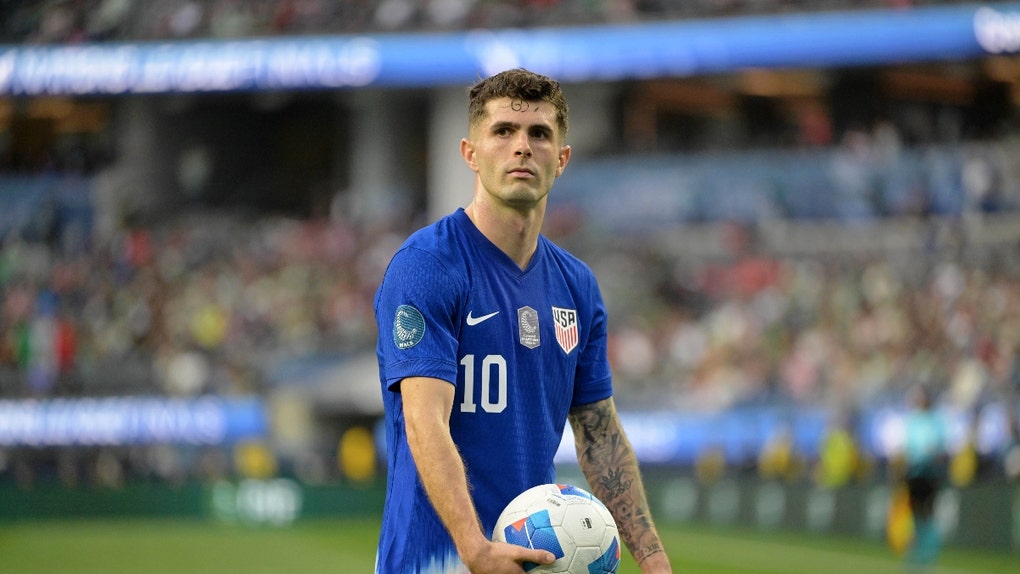 Christian Pulisic holding a soccer ball for the USMNT