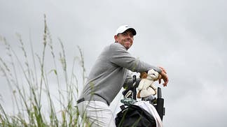Rory McIlroy leaning on his golf bag