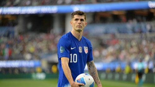 Christian Pulisic holding a soccer ball for the USMNT