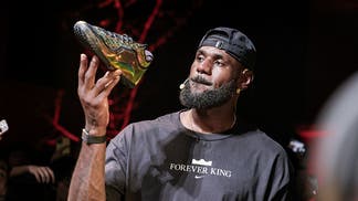 LeBron James holding his new signature shoe from Nike