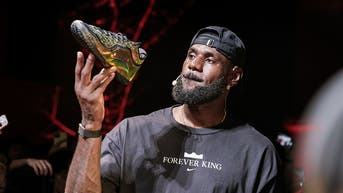 LeBron James holding his new signature shoe from Nike